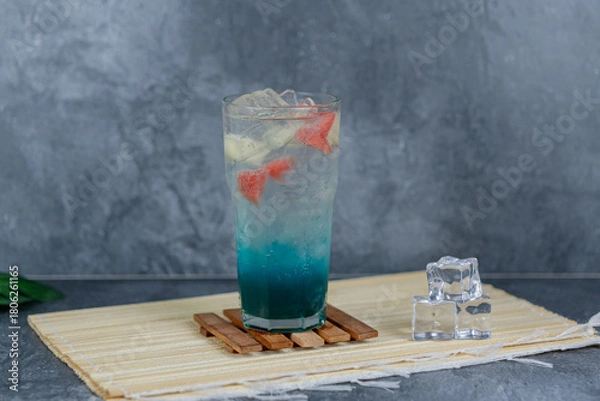 Fototapeta Refreshing fruit punch with vibrant blue hues, sparkling soda, and mixed fruit cubes. Served chilled, this drink blends tropical flair and fruity sweetness for any occasion.