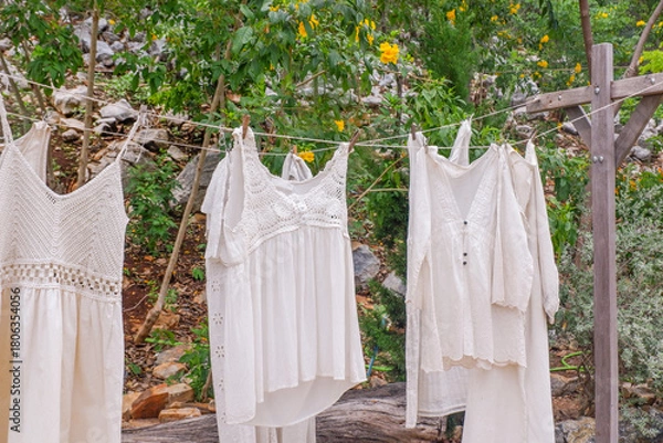 Obraz Different clothes drying on laundry line against garden background,clothes hanging laundry on washing line for drying towels drying on the clothesline.