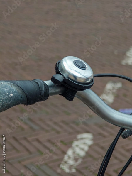 Fototapeta Rusty bike bell adds charm to vintage bicycle in quiet urban street setting with brick pavement