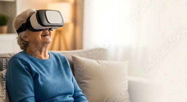 Fototapeta Smiling elderly woman wearing VR headset while sitting on sofa indoors.