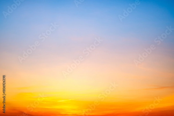 Fototapeta Sunset or sunrise sky with a vibrant gradient of orange, gold, and soft blue. Clear atmosphere with wispy clouds. Peaceful, natural light background. hope, freedom, new day and inspirational Concepts