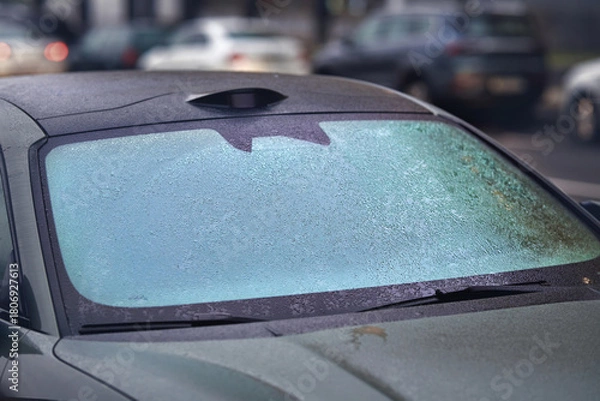 Fototapeta Car windshield completely covered in icy droplets after freezing rain, poor visibility and the cold winter weather effects that impact everyday driving safety. Frozen rain droplets. Selective focus