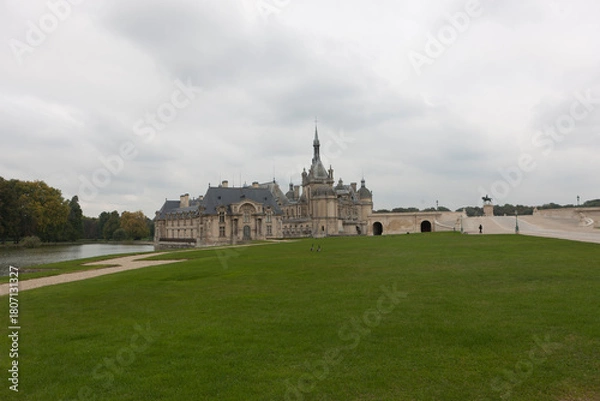 Fototapeta France's Chantilly Castle on a cloudy summer day
