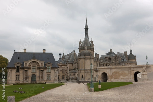 Fototapeta France's Chantilly Castle on a cloudy summer day