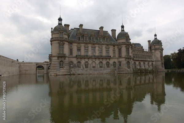 Fototapeta France's Chantilly Castle on a cloudy summer day