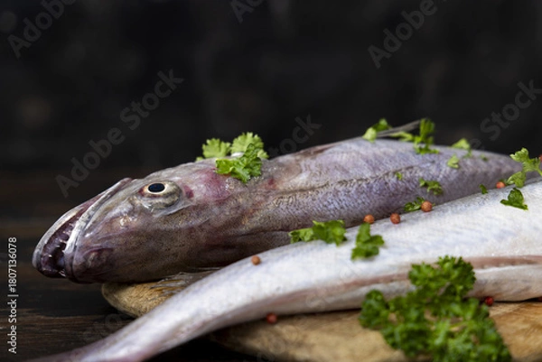 Fototapeta Fresh European hake fish on wooden board with parsley, Raw uncooked Merluccius merluccius close-up
