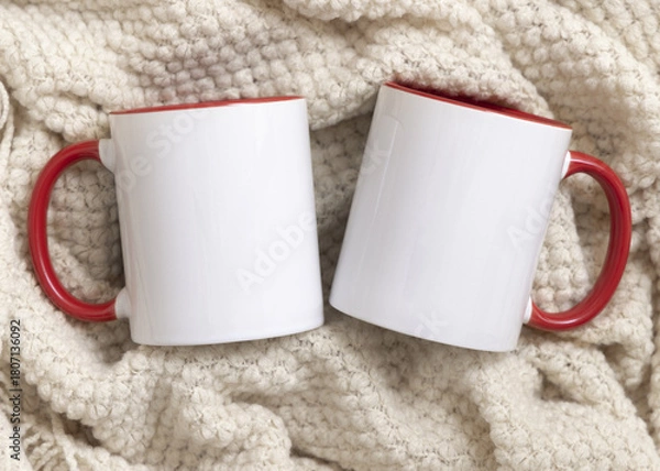 Fototapeta White accented coffee mugs with red handle on beige plaid top view, boho mockup