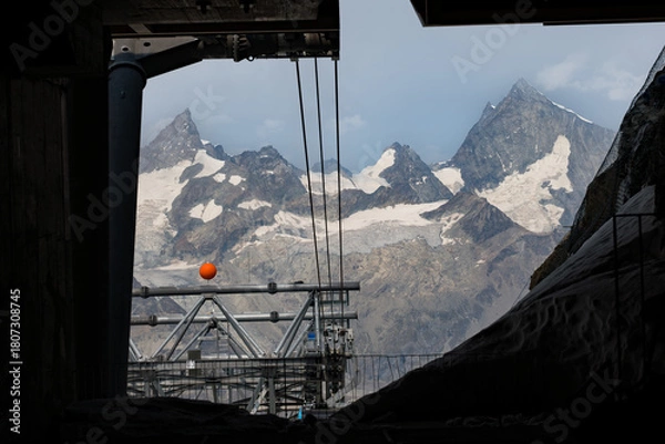 Fototapeta Glacial Paradise cable car in Zermatt, with the Swiss Alps stretching into the background under a clear alpine sky in the border of Italy and Switzerland