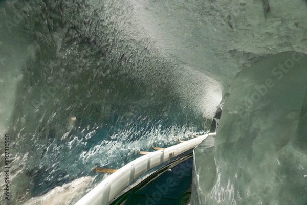 Fototapeta Ice tunnel inside the Matterhorn Glacier Paradise, Zermatt, showcasing deep blue glacial ice and shimmering alpine interiors.
