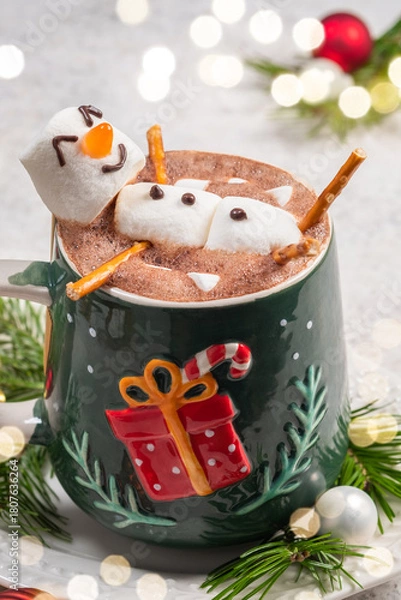 Fototapeta Enjoying a festive hot chocolate with marshmallow snowmen and holiday decorations in a cozy winter setting