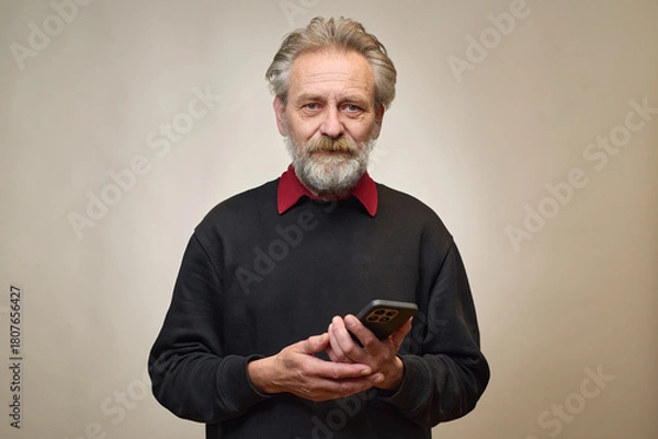 Fototapeta Old man over 60 portrait in studio with smartphone