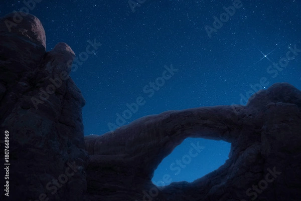 Fototapeta Dark night sky and stars creates backdrop for this Utah natural bridge