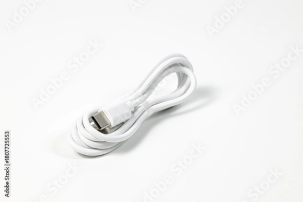 Fototapeta New white USB type charger cable in pack, compatible for many devices, wrapped in a spiral shape, isolated on white background.