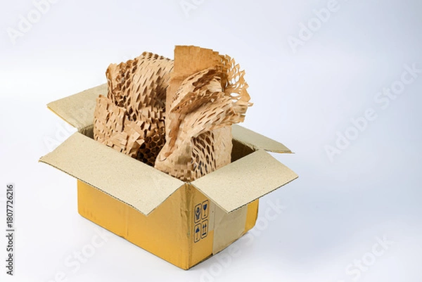 Fototapeta Item in Parcel box wrapped in eco-friendly wrapping paper, lightweight bubble wrap for protective packaging, Environmentally friendly Honeycomb paper hexagonal shape made of cardboard recycled paper.