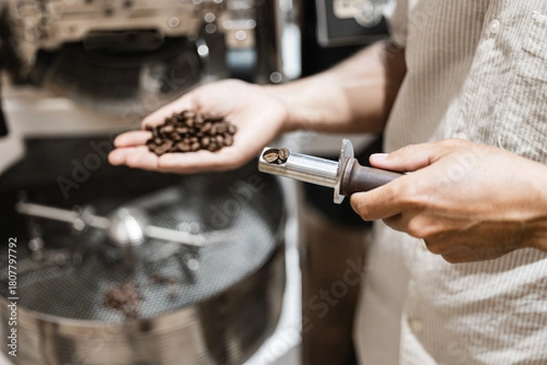 Obraz Close-up of coffee roasting process with freshly roasted beans in professional roastery setting