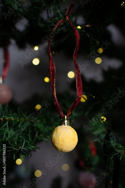 Fototapeta close up of Christmas ornaments on a green christmas tree, sparkly textured christmas tree baubles on artificial tree