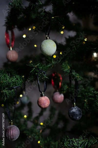 Fototapeta close up of Christmas ornaments on a green christmas tree, sparkly textured christmas tree baubles on artificial tree