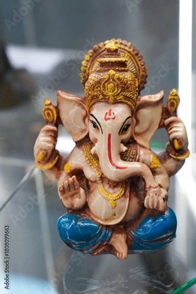 Fototapeta Russia, November 1, 2024: An intricate vintage sculpture of the Indian deity Ganesha in vibrant colors, gracefully seated surrounded by symbolic attributes. It symbolizes wisdom, prosperity,
