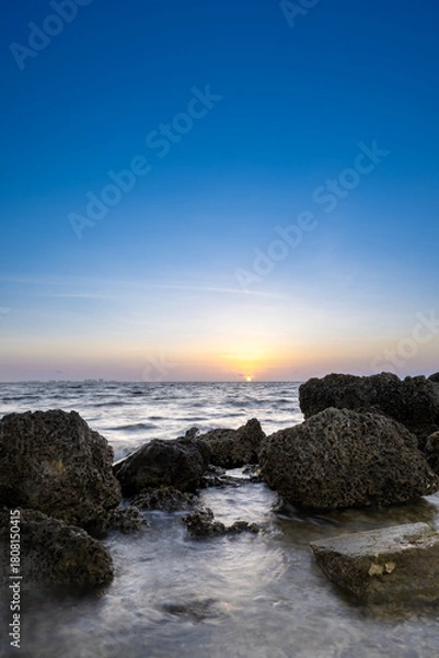 Fototapeta sunrise on the coast with limestone rocks in the foreground