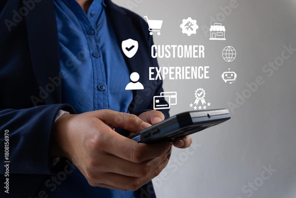 Fototapeta A woman holds a mobile phone with the screen displaying "Customer Experience." The image conveys the importance of providing a positive online customer experience.