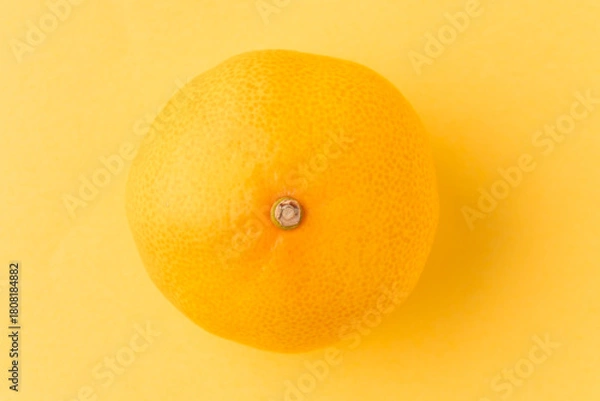 Fototapeta オレンジ色の背景に1個のみかん