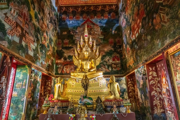 Fototapeta Buddha statue in colorful and intricately decorated temple of Wat Nak Prok, in Bangkok, Thailand.
