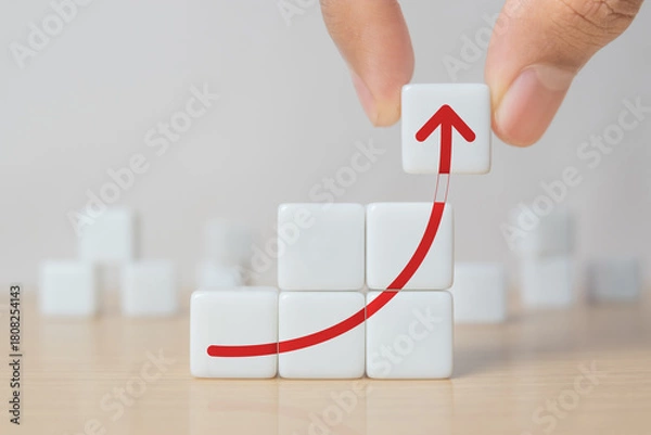 Obraz Business growth, progress or success concept. Dice with a growing graph arranged in stair shape and a man is holding the top one.