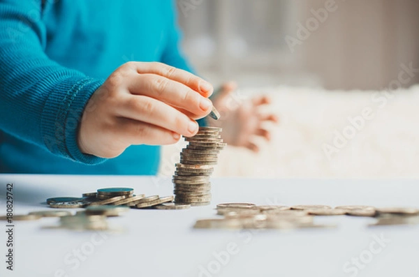 Fototapeta child coins hands slivaet in the stack