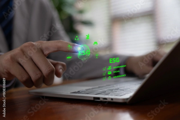 Fototapeta Experts interacting with a digital ESG interface on a laptop, focusing on environmental, social, and governance metrics that support sustainable business strategies