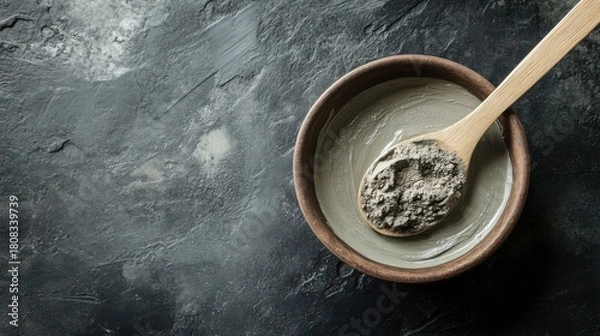 Fototapeta Clay Mask in Wooden Bowl with Spoon on Dark Surface