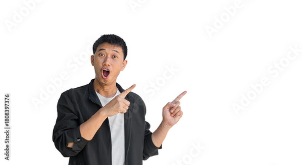 Fototapeta A young Asian man wearing black coat happy shocked face pointing thumbs up isolated on a white background. The person's index finger pointing to a blank space for text. Thai man.