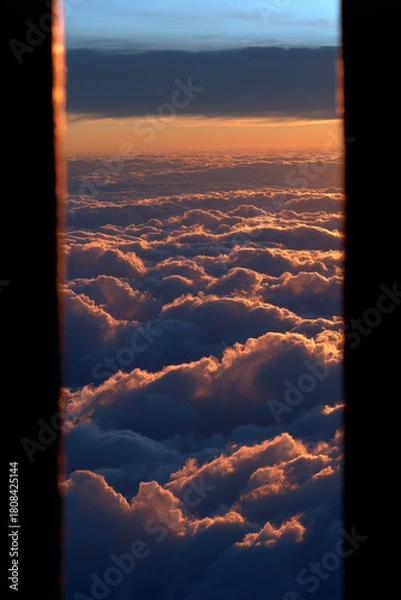 Fototapeta Rim-lit towering cloud pillars on either side of a glowing horizon with dark negative space for text