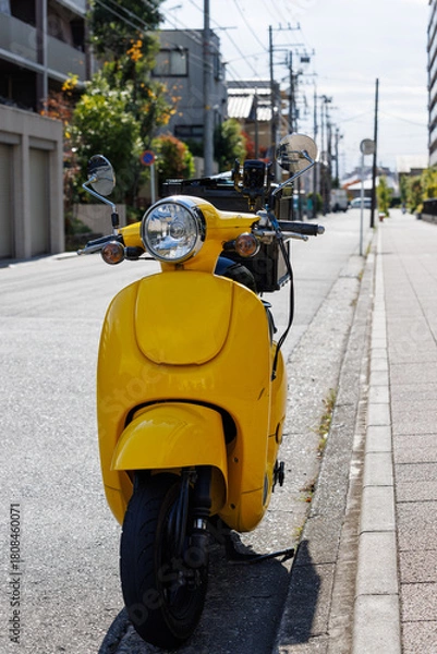 Fototapeta 道路に止まっている宅配用の黄色いオートバイ