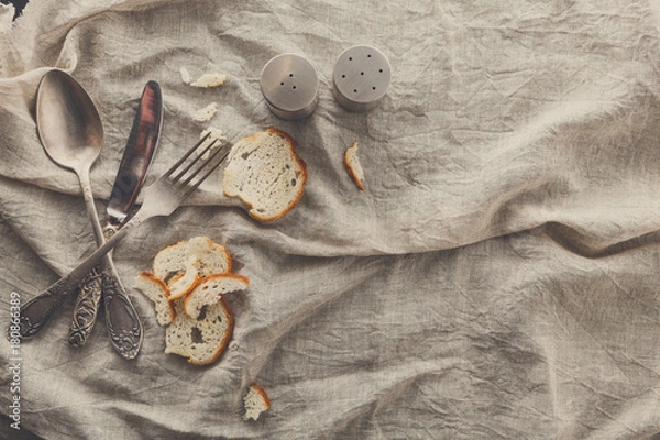 Fototapeta Cutlery with bread and spices on old fabric