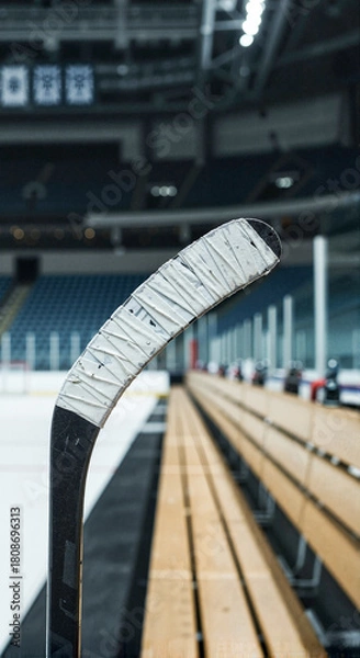 Fototapeta Ice hockey stick resting on bench in an empty arena  