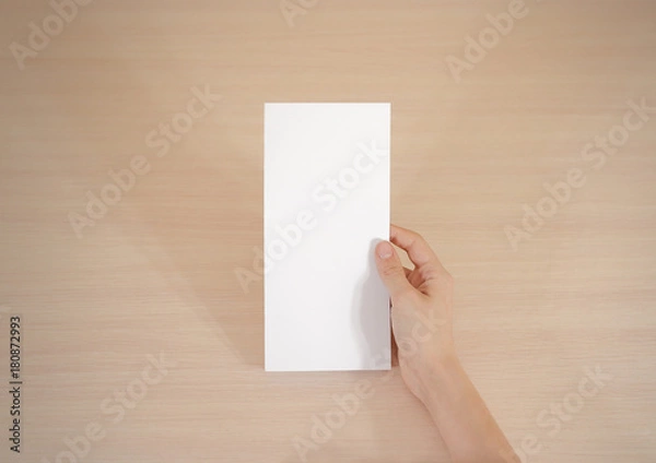 Fototapeta Hands holding blank white brochure booklet in the hand. Leaflet presentation. Pamphlet hand man. Show offset paper. Sheet template. Book in hands. Booklet folding design. Fold paper sheet display read