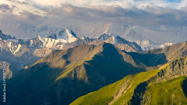 Obraz Alpine Peaks and Rolling Green Hills Under Dramatic Cloudy Skies