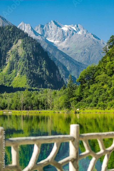 Obraz Alpine Lake with Snowcapped Peaks and Wooden Railing, Lush Forest Landscape
