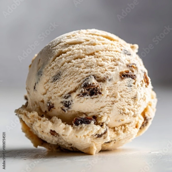 Obraz Creamy Vanilla Ice Cream Scoop with Raisins and Dark Brown Swirls on White Surface with Soft Lighting