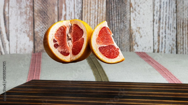 Obraz Floating Grapefruit Halves in Midair on Rustic Background