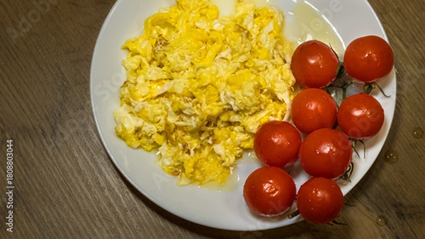 Fototapeta scrambled eggs with fresh cherry tomatoes on white plate