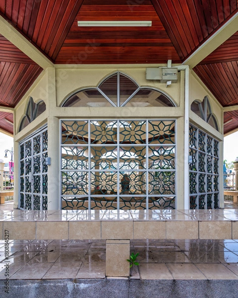 Fototapeta Raja Ayang Mausoleum, Bandar Seri Begawan, Brunei. Ornate patterned windows, rich wooden ceiling, and reflective tiled floor of the historic structure.
