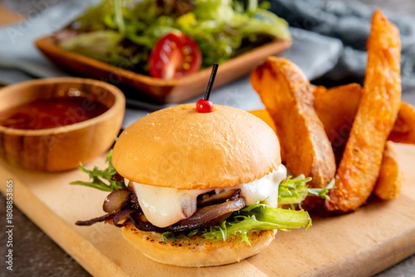 Fototapeta vegetarian mushroom burger, served with thick-cut potato wedges and a side salad toasted bun and features a thick layer of sautéed or caramelized red onions and mushrooms, melted white cheese