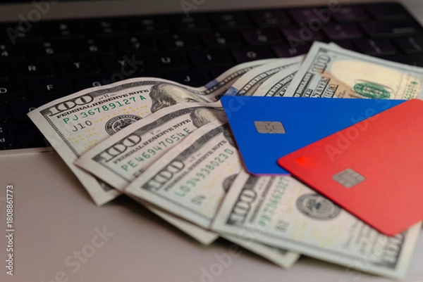 Fototapeta Credit cards and dollar bills on a keyboard close-up. Online shopping concept.