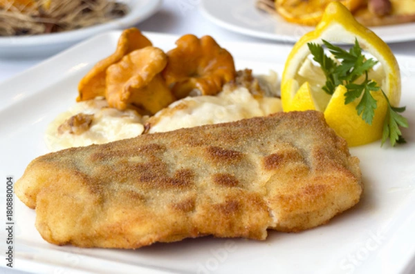 Fototapeta Christmas fried fish in breadcrumbs with chanterelle mushrooms and dumplings