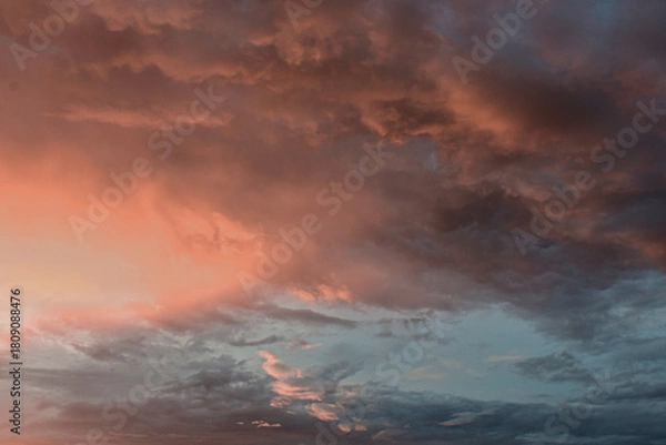 Fototapeta Dreamlike sunset sky glowing softly behind billowing clouds in harmony