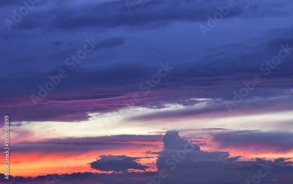 Obraz Enchanted sunset sky painted with luminous colors behind drifting clouds