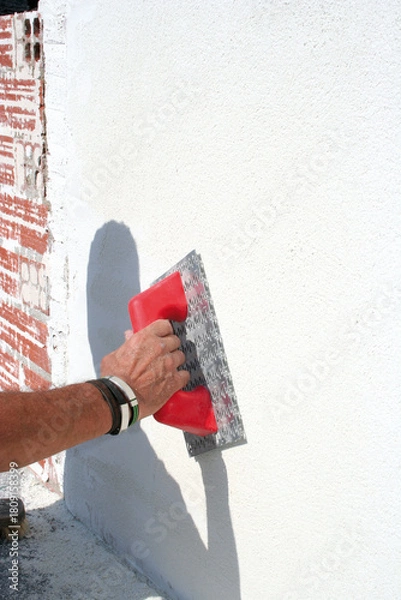 Obraz Plastering a wall with thick white paint.