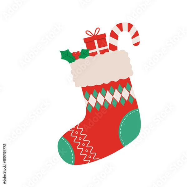 Fototapeta Festive red Christmas stocking with holly leaves, red berries, gift box and a candy cane sticking out from the top.