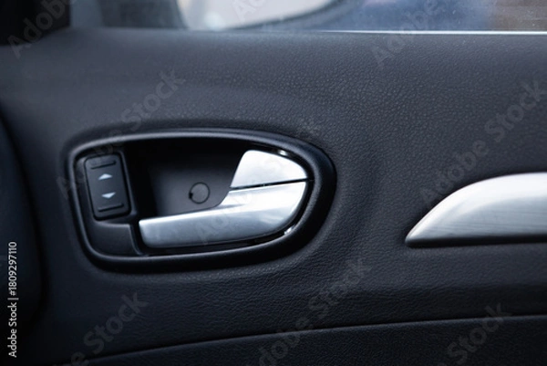 Fototapeta Car door handle with power window controls showing interior design and modern features in a vehicle